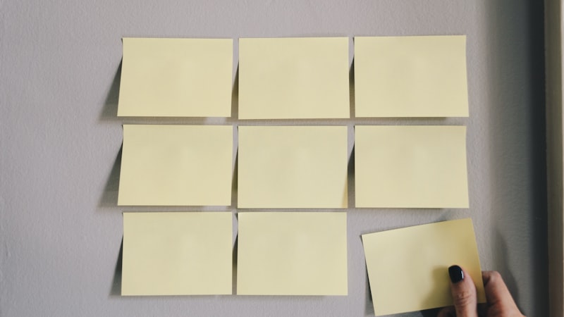 Bureau encombré de dossiers papier et post-it éparpillés