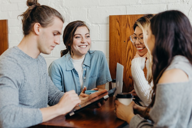Collaborateurs d'une PME partageant un moment d'équipe authentique dans leurs locaux